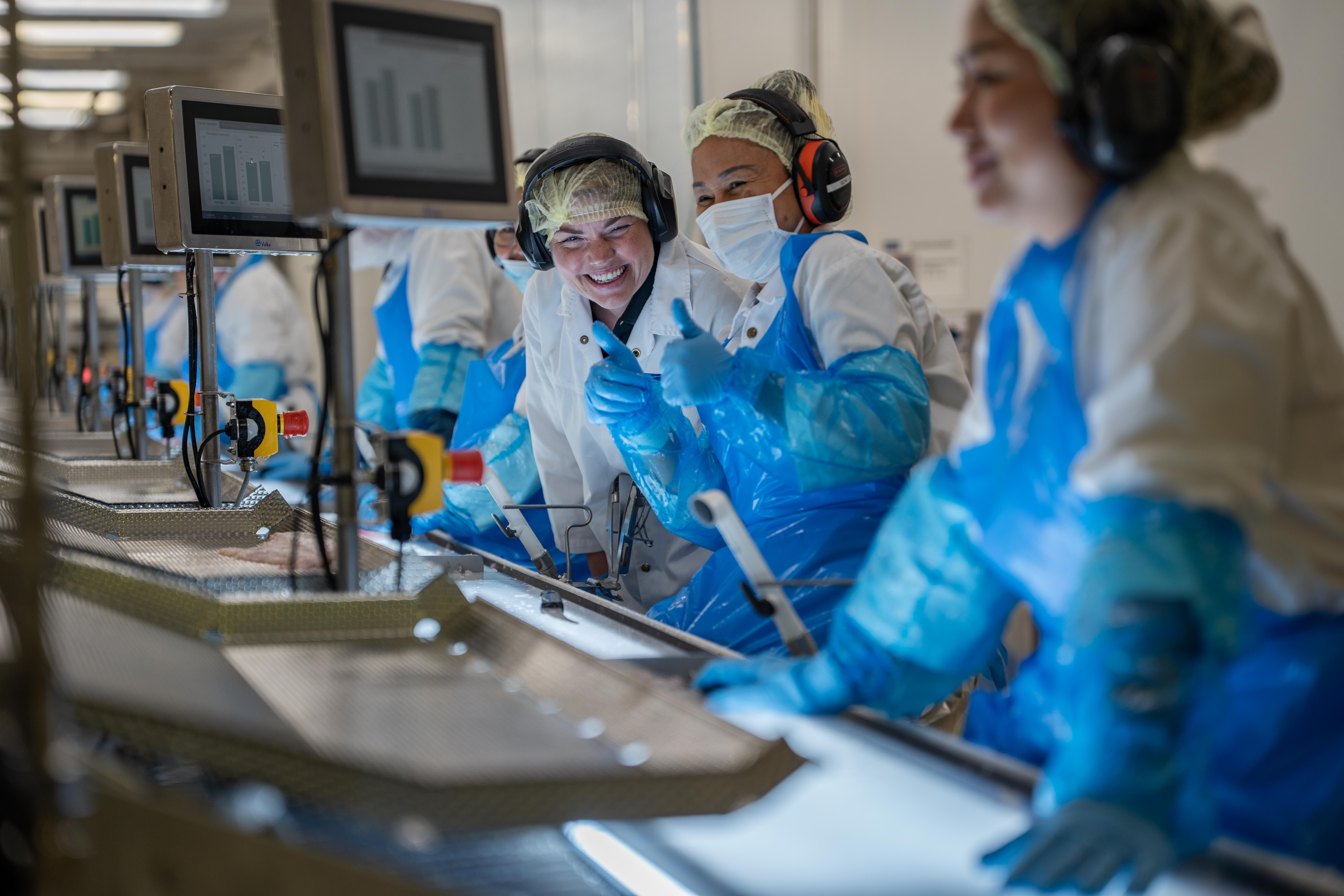 Ansatte på produksjonslinje i fabrikk